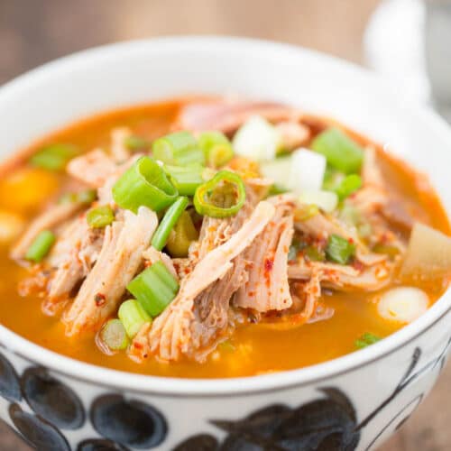 spicy turkey leftover soup in white bowl on wooden table